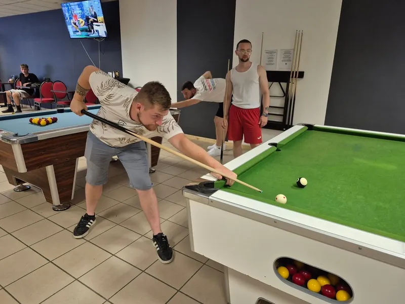 Un joueur se penche sur une table de billard au tapis vert